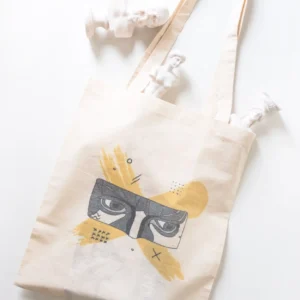 Cotton tote bag with artistic face illustration and decorative sculpture props