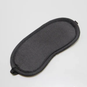 Plain black sleep mask for travel and sleep improvement on white background