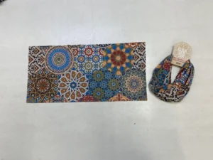 Colorful Islamic geometric buff with overlapping mandala-style motifs, shown flat and packaged